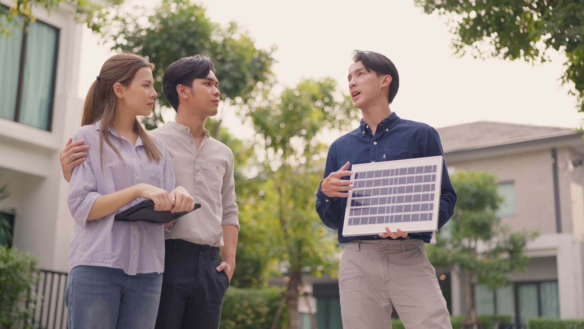 Consultant Advising Couple on Rooftop Solar Installation Options.