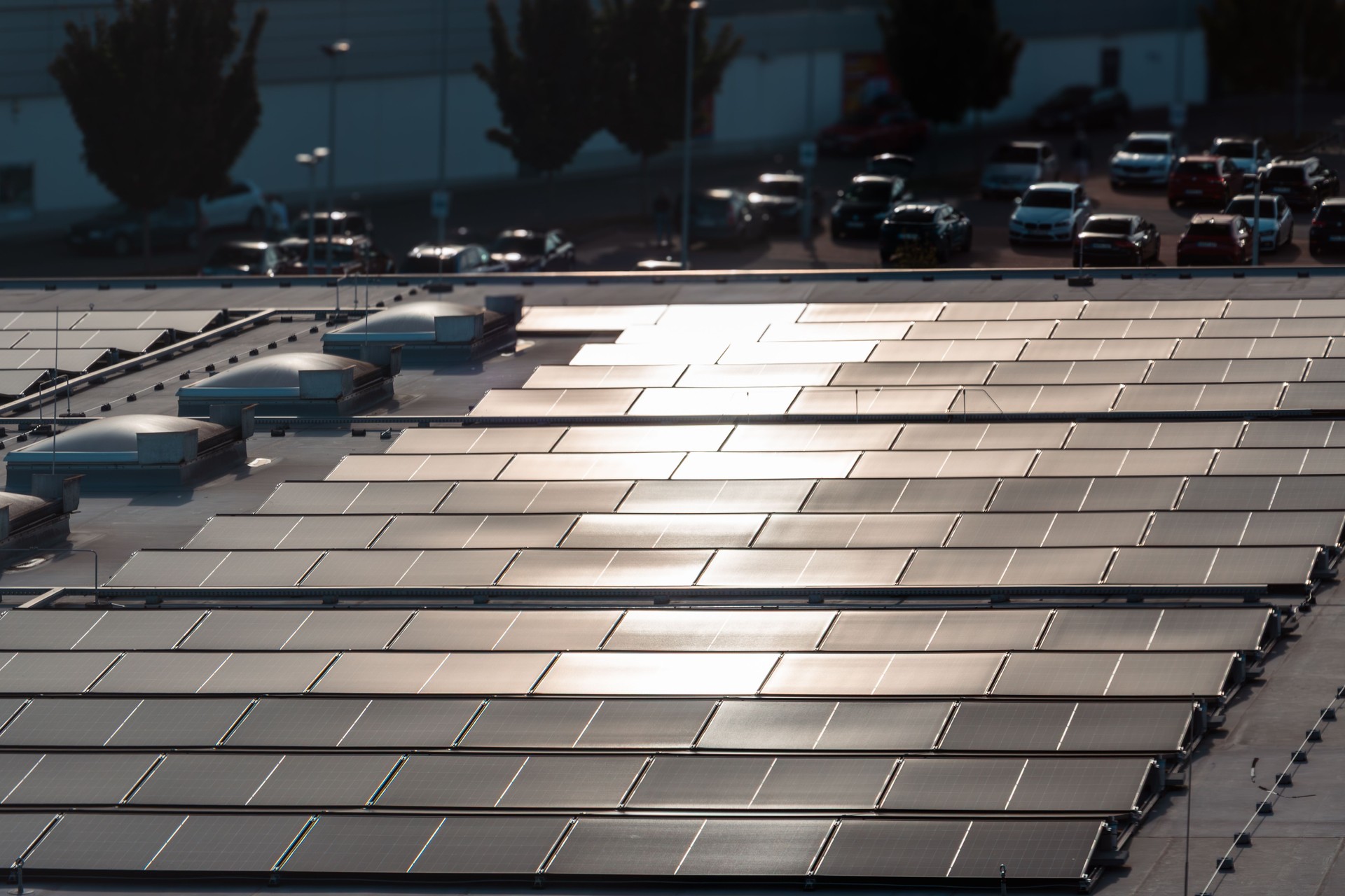 Große Solarpanel-Anlage auf dem Dach mit urbanem Hintergrund und Reflexionen